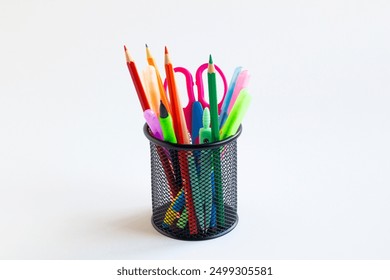 Colorful office or school supplies in a black metal pencil case on white surface with copy space - Powered by Shutterstock