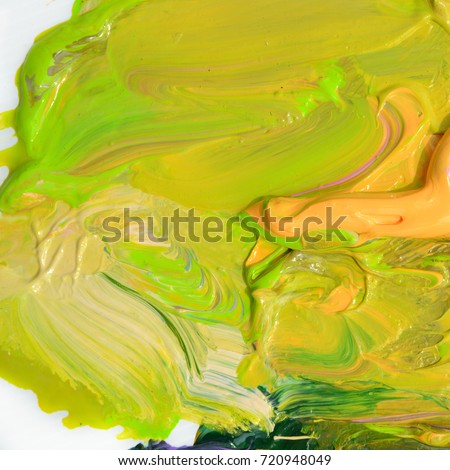 Colorful oil paint of different colors on a palette on white background