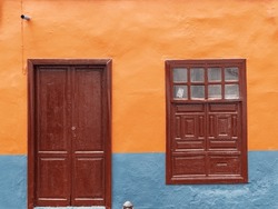 Colorful Old House Facade, Freshly Painted In Orange And Blue With Old Wooden Door And Old Window.