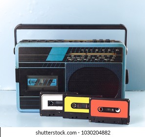 Colorful old music recorder with casette tape on bright blue background. White, yellow, red
