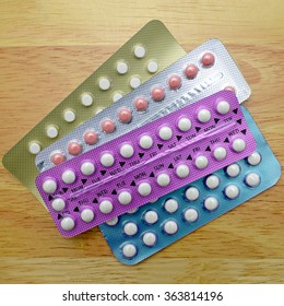 Colorful Oral Contraceptive Pill Strips On Pine Wood Table.