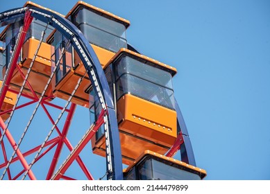 Colorful Orange Passenger Cabins On Red White And Blue Ferris Wheel