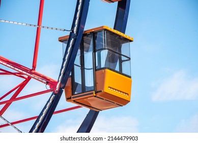 Colorful Orange Passenger Cabins on Red White and Blue Ferris Wheel - Powered by Shutterstock