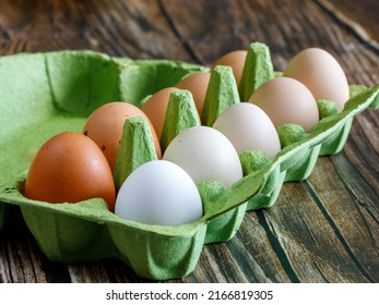 Colorful organic chicken eggs in green egg carton. These eggs were produced in small batches by a variety of chicken species so they appeared in different colors, patterns, and sizes. Side view