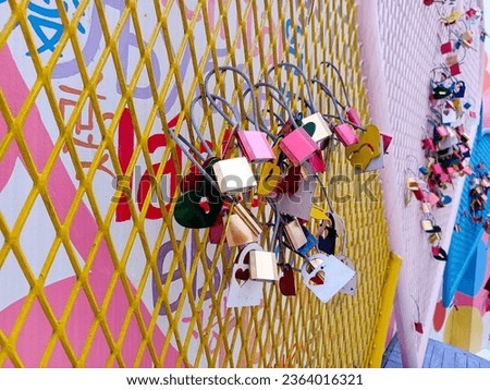 Colorful padlocks or security locks attached to the fence as the symbol of love. The love lock tradition is a romantic ritual symbolizes eternal love, locking hearts and sealing love.