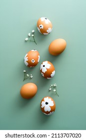 Colorful painted Easter eggs on green background with gypsophila. Elegant Easter flat lay composition