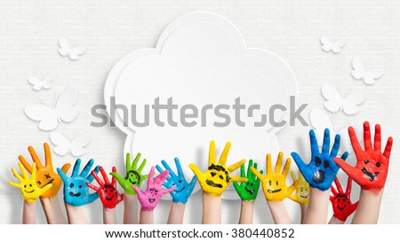 colorful painted hands in front of a decorated wall with a flower and butterflies