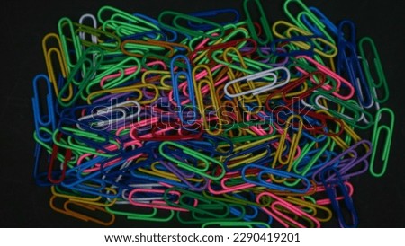 Similar – Colorful paper clips on a black board surface