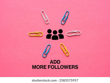 Colorful paper clips pointing to followers icon and add more followers writing on pink background representing attracting more followers on social media