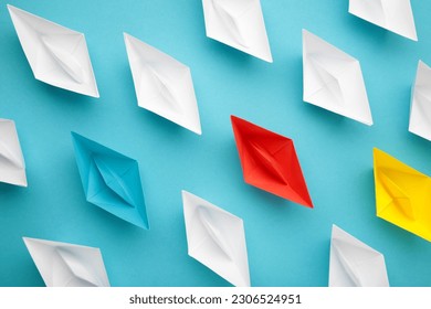 Colorful paper ships on blue background, Leadership and Business competition concepts. Top view - Shutterstock ID 2306524951