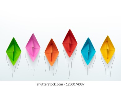 Colorful paper ships on white background, Leadership and Business competition concepts. Copy space