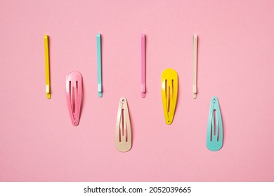 Colorful pastel accessories hairpin on pink background, close up, top view, trendy modern from past