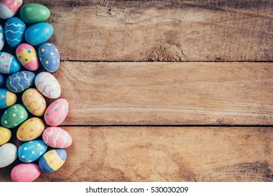 Colorful pastel easter eggs on wooden background with space. Vintage toned.