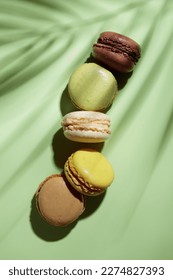 Colorful pastel eco handmade macaroons on green background with a shadow. Gift for 8 March, International Women's Day, Valentine Day. Vertical banner