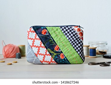Colorful Patchwork Quilted Makeup Bag And Quilting Supplies On The Wooden Desk