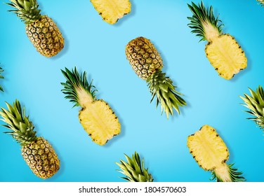 Colorful pattern of pineapples on pastel blue background.