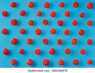 Colorful Pattern Of Ripe Raspberry Berries On A Bright Blue Background. Top View, Berry Background