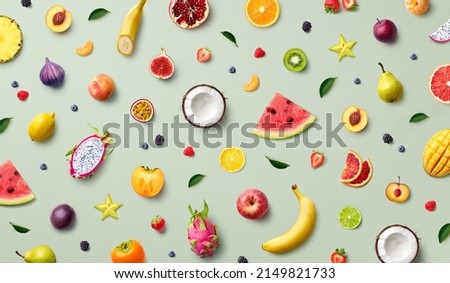 Colorful pattern of various fresh whole and sliced ripe fruits and berries, top view, flat lay. Exotic summer food concept.