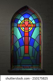 A Colorful Patterned Stain Glass Window With The Shape Of A Crucifix Designed Into It Highlighted With A Beam Of Light Shining Through It On An Isolated Wall Space