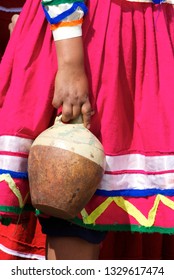 Colorful Peasant Skirt From Apurimac Contrasts With Colonial Clay Pot
 To Serve Chicha