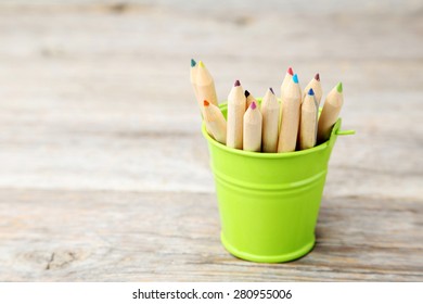 Colorful pencils in bucket on grey wooden background - Powered by Shutterstock