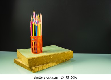 Colorful pencils and pile of books, back to school concept
