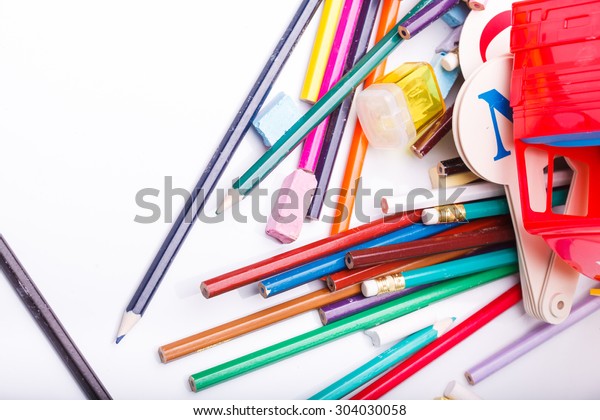 Colorful pencils of red\
yellow orange violet purple pink green blue chalk fan english\
alphabet and truck car toy lying on white school desk background,\
horizontal photo