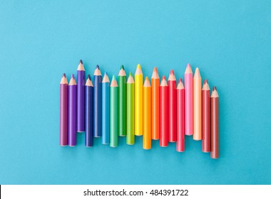Colorful pens in colors of the rainbow on blue