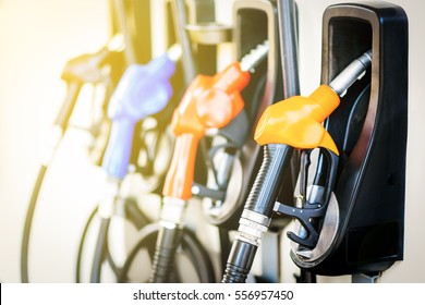 Colorful Petrol pump filling nozzles isolated on white background , Gas station in a service in warm sunset  - Shutterstock ID 556957450