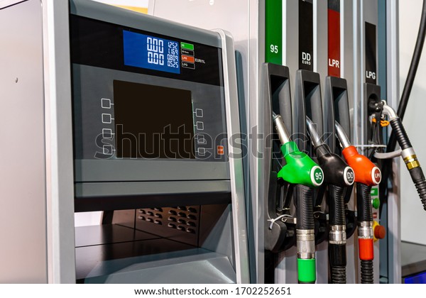 Colorful Petrol pump filling nozzles , Gas station\
in a service in daytime -\
image