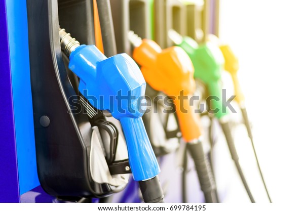 Colorful Petrol\
pump filling nozzles isolated on white background , Gas station in\
a service in warm\
sunlight