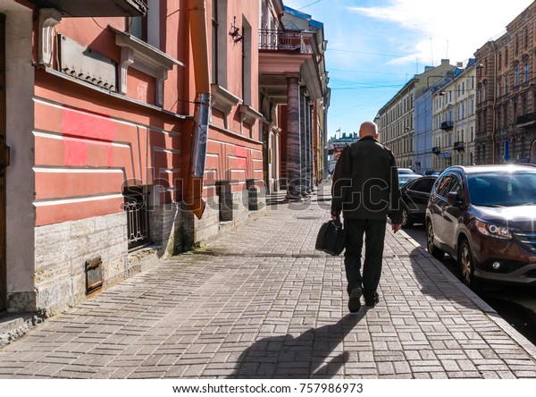 Colorful photo of an old man walking on the\
street in the city during\
daylight