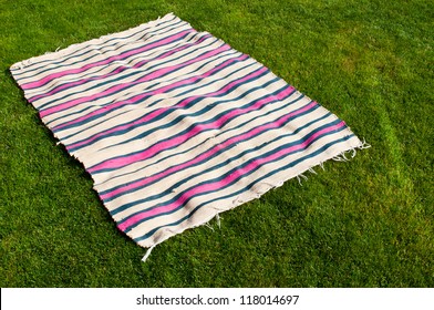 Colorful Picnic Blanket On The Grass Field