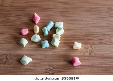 Colorful Pillow Mints Made From Scratch At Home; Home Made Butter Mints Scattered On A Wooden Cutting Board