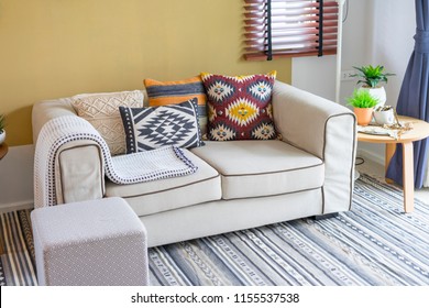 colorful pillow with native american pattern on biege sofa in living room.