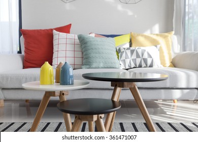 Colorful pillows on a sofa with little vase in foreground