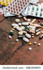Colorful pills and capsules on wooden table