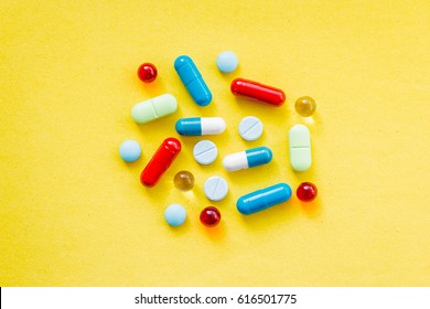 colorful pills and drugs in close up.assorted pills and capsules in medicine. drugs of various kinds and different colors. Medicine on yellow background - Shutterstock ID 616501775