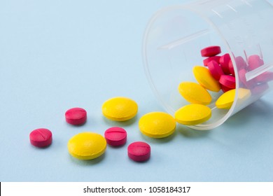 Colorful Pills Pouring Out Of  The Dosage Cup