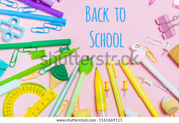 Colorful pink background with various School\
accessories are laid out in the form of a rainbow. Empty notebook.\
Flat lay top view. Study arrangement, making wish list or plans.\
Back to school text.
