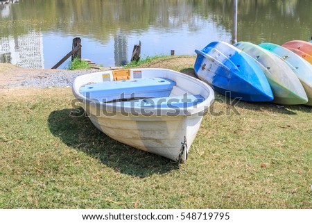 Colorful plastic boats stack on grass outdoors