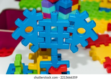 Colorful Plastic Constructor Set For Children. Multicolored Puzzle Blocks Of The Children's Constructor Are Connected Into Shapes. Concept Of Childhood And Games, Business And Cooperation