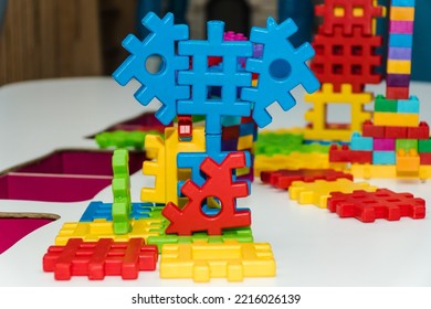 Colorful Plastic Constructor Set For Children. Multicolored Puzzle Blocks Of The Children's Constructor Are Connected Into Shapes. Concept Of Childhood And Games, Business And Cooperation