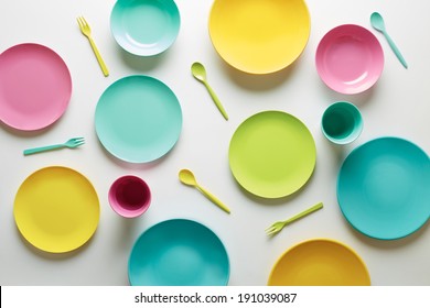 Colorful Plastic Dishes On White Background Overlook Shot