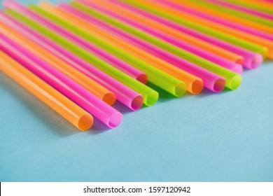 Colorful plastic Drink straws on blue background.  Equipment for single use. Plastic pollution, waste, eco, ecology, recycle. Plastic processing problem. Close up. Copy space