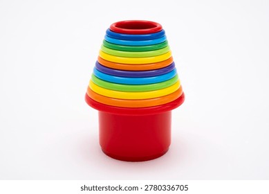 Colorful plastic nesting buckets and stacking cups for toddlers, vibrant educational toy set for early development of motor skills and logic, isolated on clean white background studio shot.