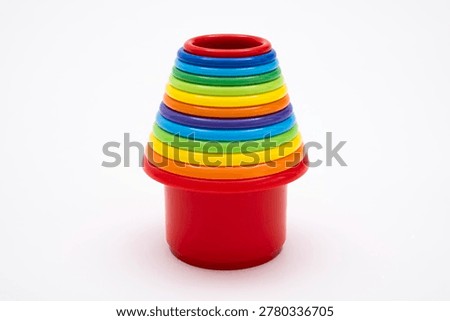 Colorful plastic nesting buckets and stacking cups for toddlers, vibrant educational toy set for early development of motor skills and logic, isolated on clean white background studio shot.
