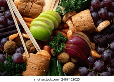 Colorful platter full of apple slices, carrots, grapes, cheese, Oranges, dark chocolates and bread - Powered by Shutterstock