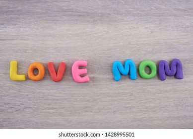 Colorful Play Doh Shaped Into Letters Love Mom On Wooden Background