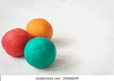 Colorful Playdough Balls On Wooden Table.